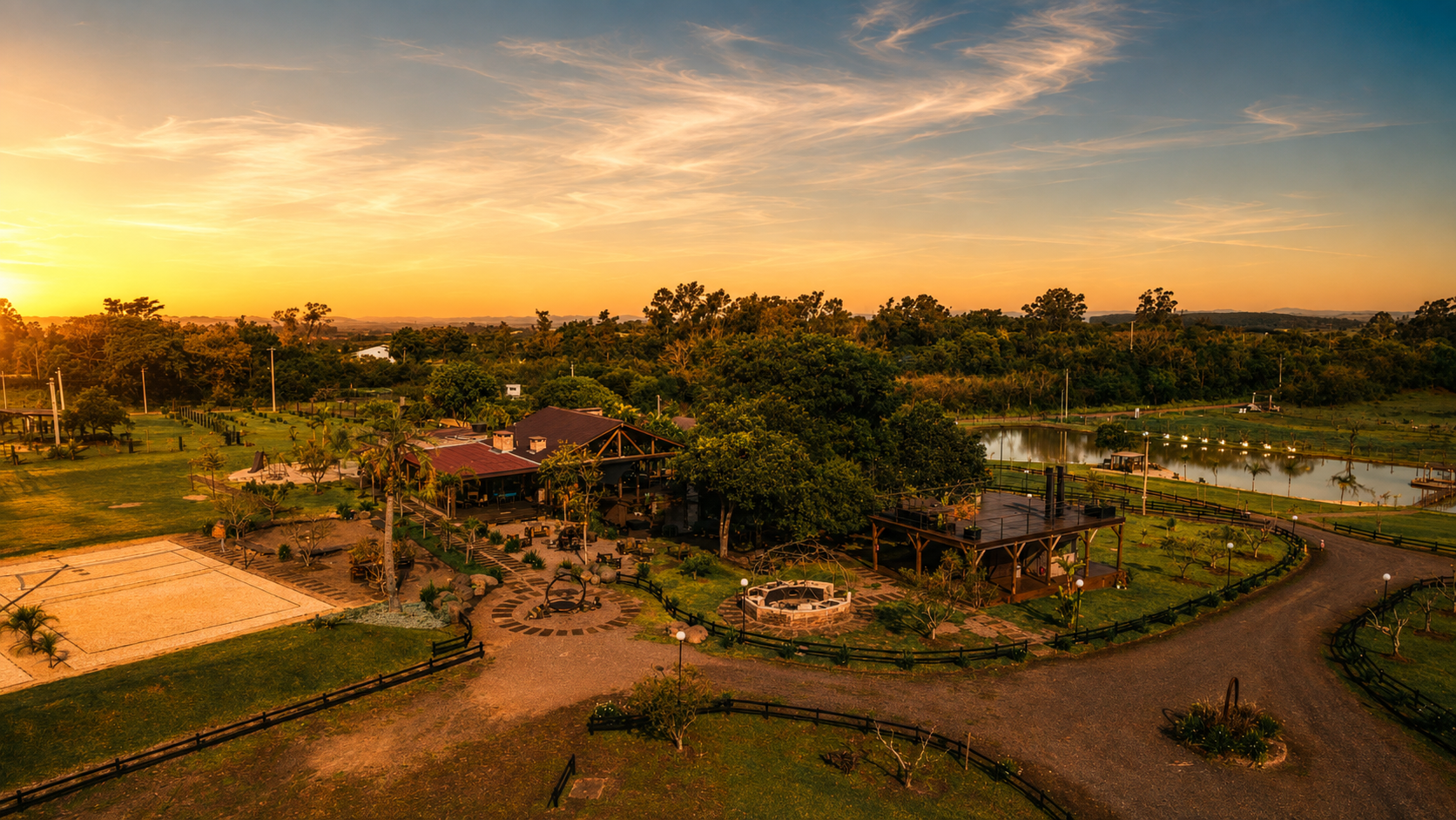 Esphera Glamping durante a golden hour — sede, grande árvore central, lago e caminhos iluminados pelo pôr do sol